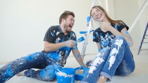 Feliz casal charmoso se divertindo e pintando um quarto em sua nova casa — Vídeo de Stock