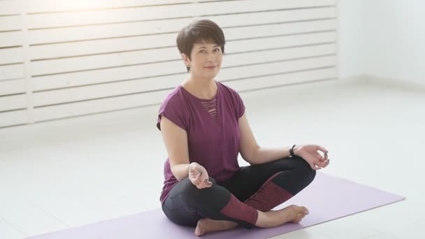 Mellersta åldern yogi attraktiv kvinna utövar yoga inomhus — Stockvideo