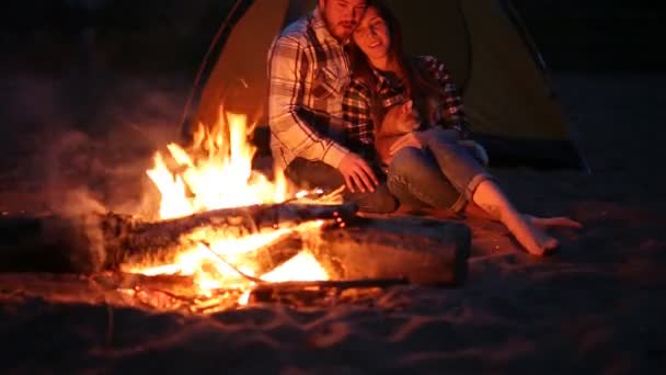 Concepto de viaje y amor. Joven pareja encantadora cerca de la chimenea en el campamento — Vídeos de Stock