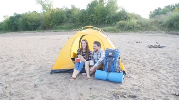 Young gelukkige paar met kat zitten in de tent tijdens het wandelen trip — Stockvideo