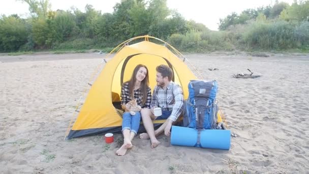 Giovane coppia felice con gatto seduto in tenda durante il viaggio di trekking — Video Stock