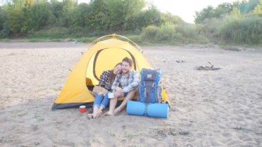 Gezi sırasında hiking çadır içinde oturan kedi ile genç mutlu çift