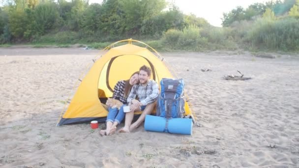 Jeune couple heureux avec chat assis dans la tente pendant le voyage de randonnée — Video