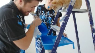 Yeni Emlak kavramı. Genç kedi boyama ve yenileme ile çift onların yeni evinde bir oda