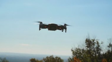 Kişisel sondalar ve hava fotoğrafçılığı kavramı. Ek yükü bulutlu mavi gökyüzünde uçan Quadcopter