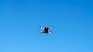 Kişisel sondalar ve hava fotoğrafçılığı kavramı. Ek yükü bulutlu mavi gökyüzünde uçan Quadcopter