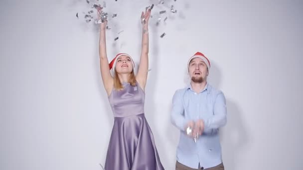 Gelukkig mooi paar in Santa hoeden dansen en lachen — Stockvideo