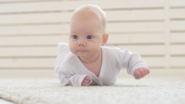 Konzept von Kindern und Elternschaft. Niedliches glückliches Baby liegt auf Teppich — Stockvideo