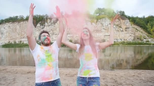 Tatil, bayram ve insanlar kavramı - mutlu çift holi boya toz kaplı eğleniyor — Stok video