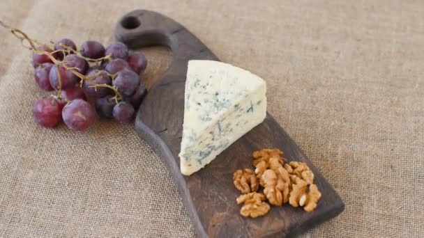 El queso azul y las nueces giran sobre una mesa de servir de madera — Vídeos de Stock