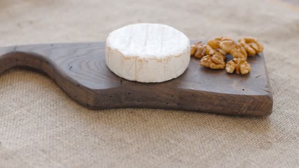 Τυρί λευκό μούχλα περιστροφή σε ένα ξύλινο κοπή του σκάφους — Αρχείο Βίντεο