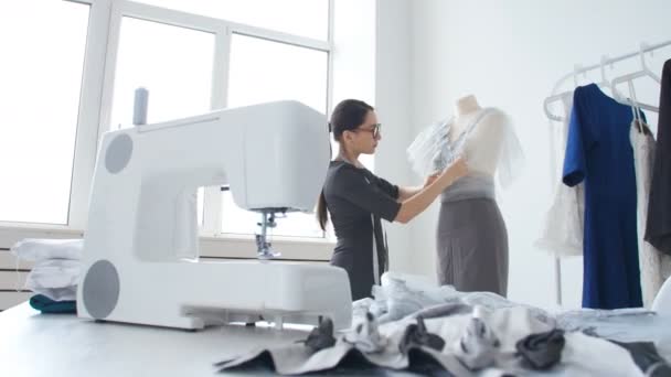 Concepto de pequeña empresa y pequeña producción. Joven bonita modista mujer cose ropa en el taller — Vídeos de Stock