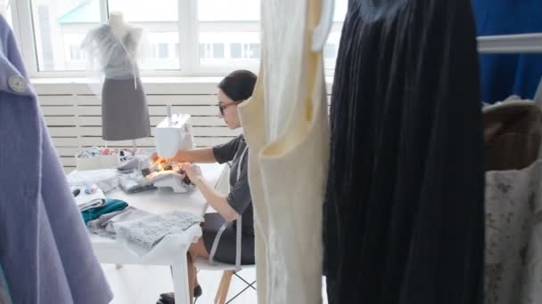 Couture Hobby et un concept de petite entreprise. Jeune jolie couturière couture sur machine à coudre. tailleur faire un vêtement dans son lieu de travail — Video