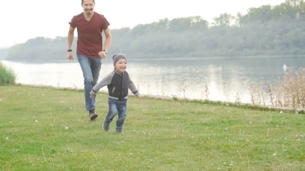 Familien- und Kinderkonzept. Glücklicher Vater und Sohn haben Spaß im Sommerpark — Stockvideo