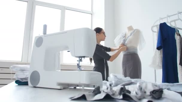 Концепция хобби и малого бизнеса. Молодая женщина швея проектирует и шьет одежду — стоковое видео