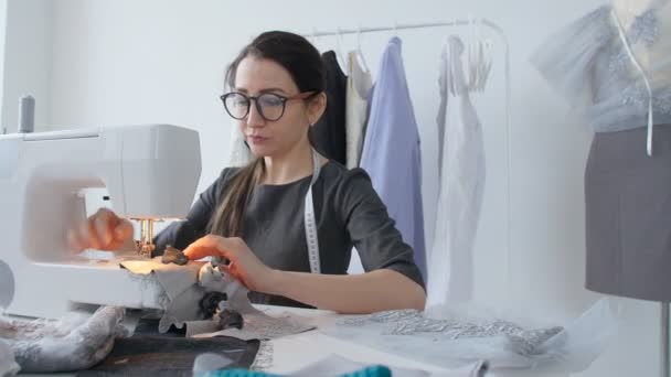 Концепция хобби и малого бизнеса. Молодая женщина швея проектирует и шьет одежду — стоковое видео