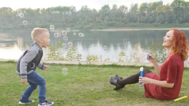 Family and children concept. Young mother with son walking by the river — Stok video