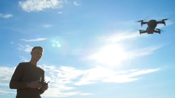 Concept of personal drones and aerial photography. Young man with a quadrocopter remote control — Stock Video