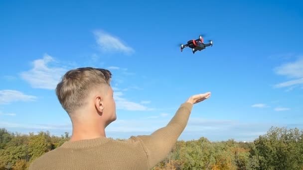 Conceito de drones pessoais e fotografia aérea. Quadcopter pousa na palma da mão — Vídeo de Stock
