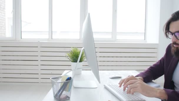 Conceito de freelancer e escritório de trabalho. Jovem e elegante funcionário olhando para monitor de computador durante o dia de trabalho no escritório — Vídeo de Stock