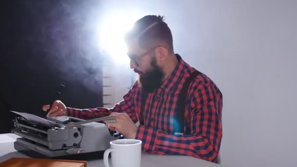 Concepto de escritor retro. Joven barbudo elegante hombre escribiendo en la vieja máquina de escribir — Vídeos de Stock