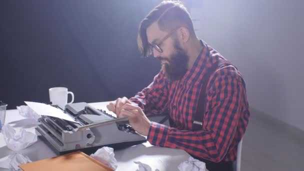 Concepto de escritor retro. Joven barbudo elegante hombre escribiendo en la vieja máquina de escribir — Vídeo de stock