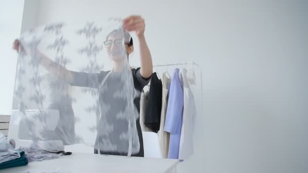Concept van het ontwerp en de productie van kleding. Jonge naaister kleding ontwerper werken in zijn atelier — Stockvideo