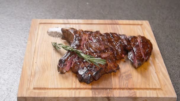 Pişirme kavramı. Marine edilmiş ızgara sığır eti biftek ahşap tahta üzerinde yan — Stok video
