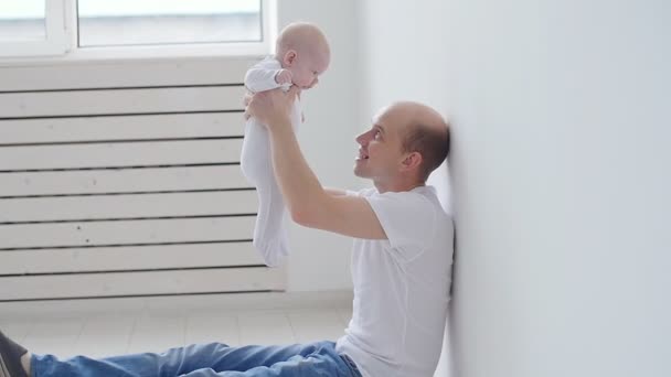Концепция семьи и детей. Счастливый молодой отец держит свою новорожденную дочь — стоковое видео