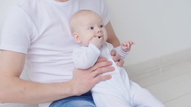 Concepto de familia e hijos. Feliz padre joven sostiene a su hija recién nacida — Vídeos de Stock