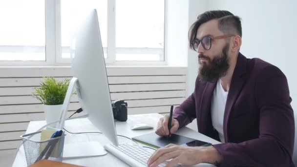 Konzept des Grafikdesigns und der professionellen Fotografie. junger männlicher Grafikdesigner, Fotograf im Büro oder zu Hause — Stockvideo