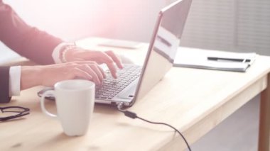 Güneşli ofiste onun masasında oturan genç adam