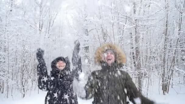 Caminata de invierno y concepto turístico. Joven pareja feliz caminar y divertirse en el bosque en invierno — Vídeo de stock