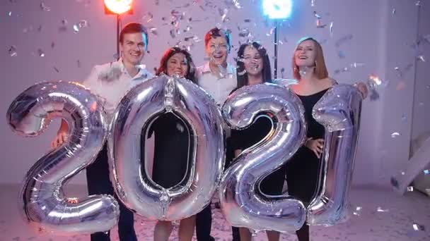 Año nuevo 2021 concepto. Grupo de jóvenes alegres sosteniendo globos numéricos, bañados con confeti — Vídeo de stock