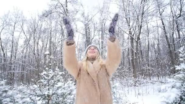 冬の楽しみ。冬の森や公園で雪を投げる女性 — ストック動画