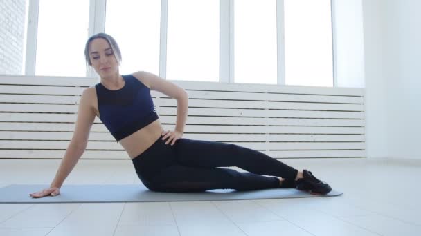 Koncepce domácí fitness a sportu. Mladá žena, která dělá fitness cvičení v bílý interiér — Stock video