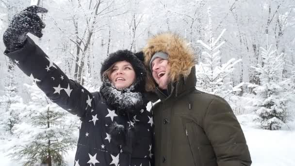 年轻的幸福夫妇在雪堆的森林里被拍到自拍。冬季旅行概念 — 图库视频影像