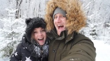 Genç mutlu çift selfie karlı bir ormanda fotoğrafı var. Kış seyahat kavramı