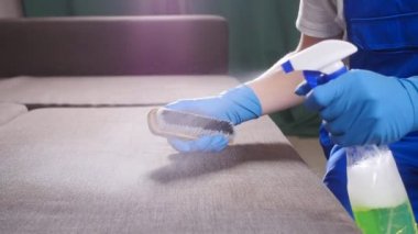 Daire veya ofis temizlik kavramı. Kanepede bir fırça ile işçi temizler