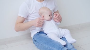 Genç mutlu baba beyaz iç kapalı onun bebekle zaman harcıyor