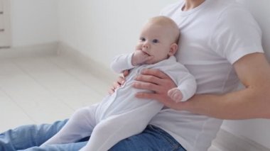 Genç mutlu baba onun bebek beyaz iç ile vakit geçiriyor
