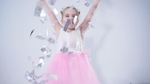 Concepto de fiesta y fiesta. Feliz niña lanzando confeti — Vídeo de stock
