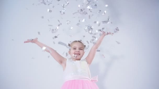 Concept of holiday and party. Happy little girl throwing confetti — Stock Video