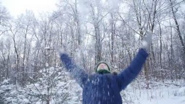 Genç çocuk kış ormanına kar atıyor. Aktif yaşam tarzı, kış aktivitesi, açık hava kış oyunları konsepti