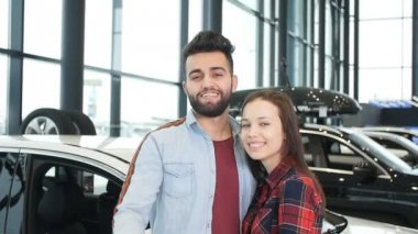 Satın alma veya bir araba kiralamak kavramı. Yeni araba anahtarları ile genç mutlu ırklararası çift