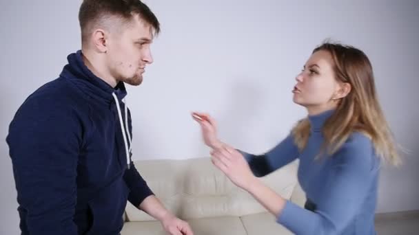 O conceito de violência doméstica. Um homem bate uma jovem mulher em casa . — Vídeo de Stock