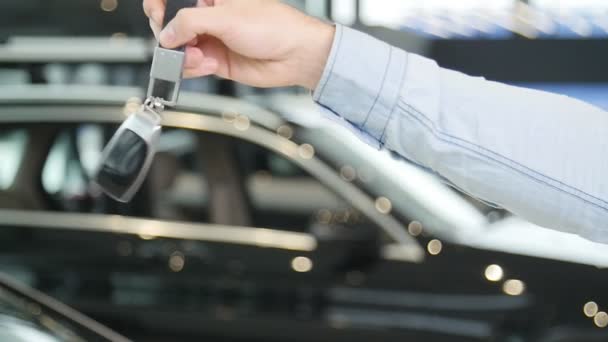 El concepto de comprar o alquilar un coche. Mano con llaves del coche nuevo — Vídeos de Stock