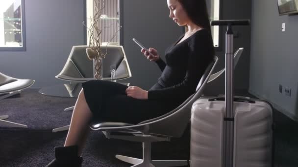 Jonge vrouw te wachten voor vertrek in de business lounge op de luchthaven — Stockvideo