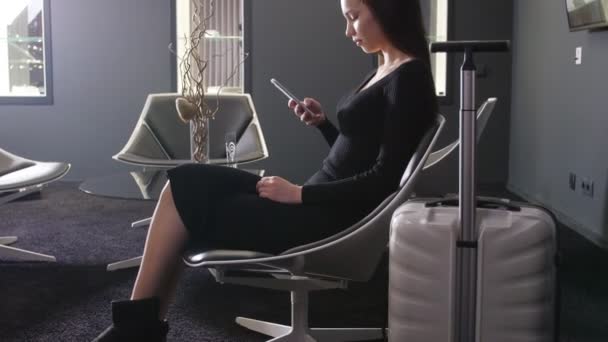 Young woman waiting for departure in the business lounge at the airport — Stock Video