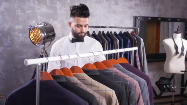 Jonge Man Met Baard Kiezen Pak Een Winkel Binnen — Stockvideo